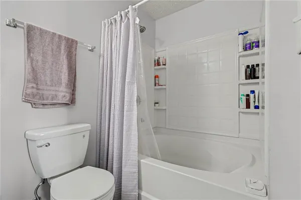 a white toilet sitting next to a bath tub