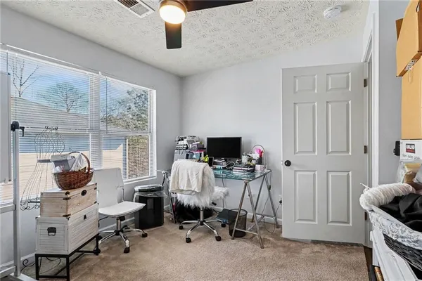 a view of a workspace with furniture and a window