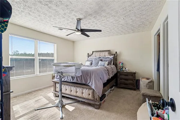 a bedroom with a bed chandelier and a window