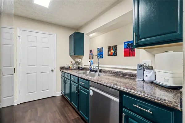 a kitchen with stainless steel appliances granite countertop a sink and dishwasher with wooden floor