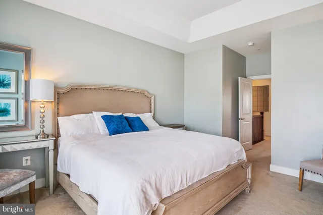 a bedroom with a bed and a flat tv screen on wall