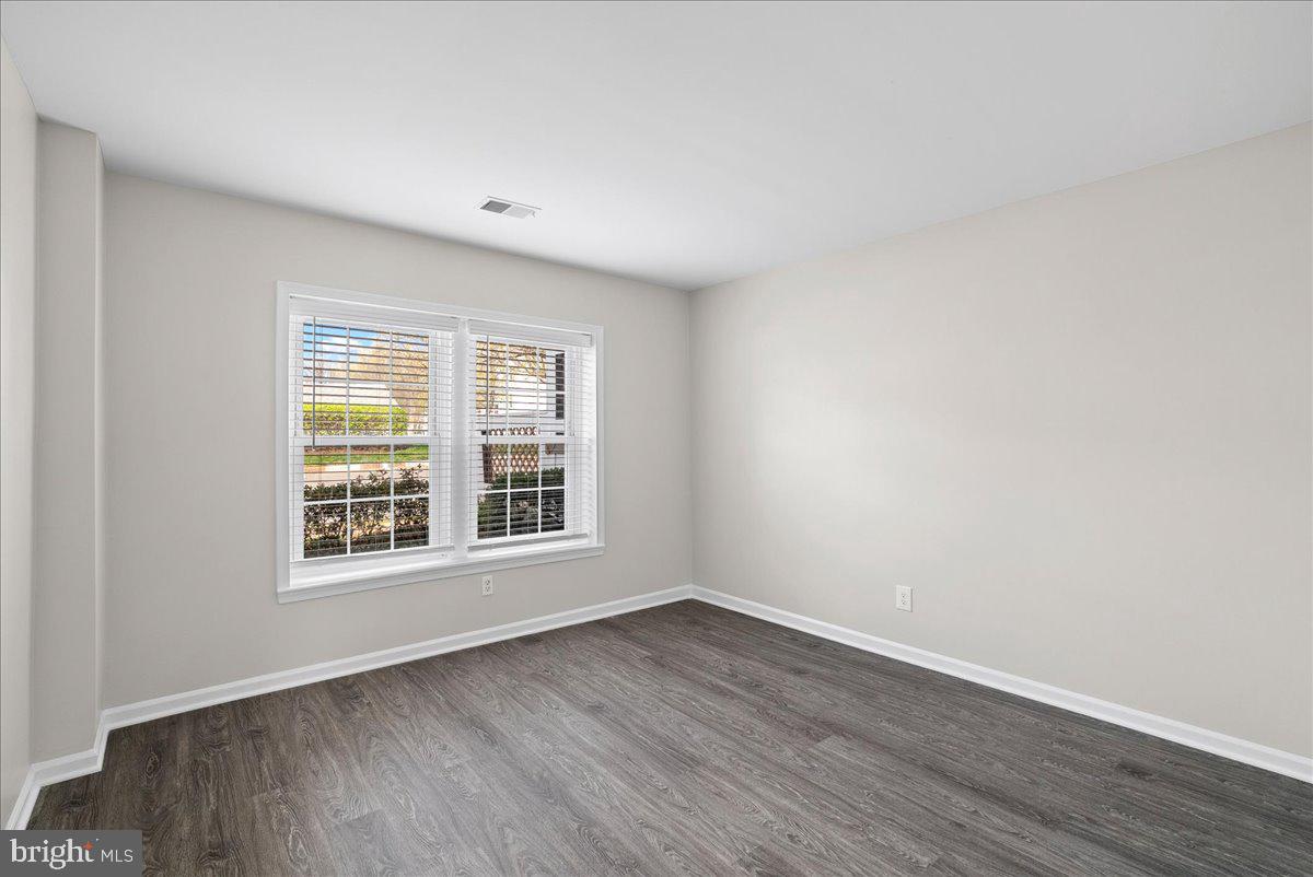 12942 A Grays Pointe Road, Unit 12942A Fairfax, VA 22033 - Photo 13 of 22 a view of an empty room with wooden floor and a window