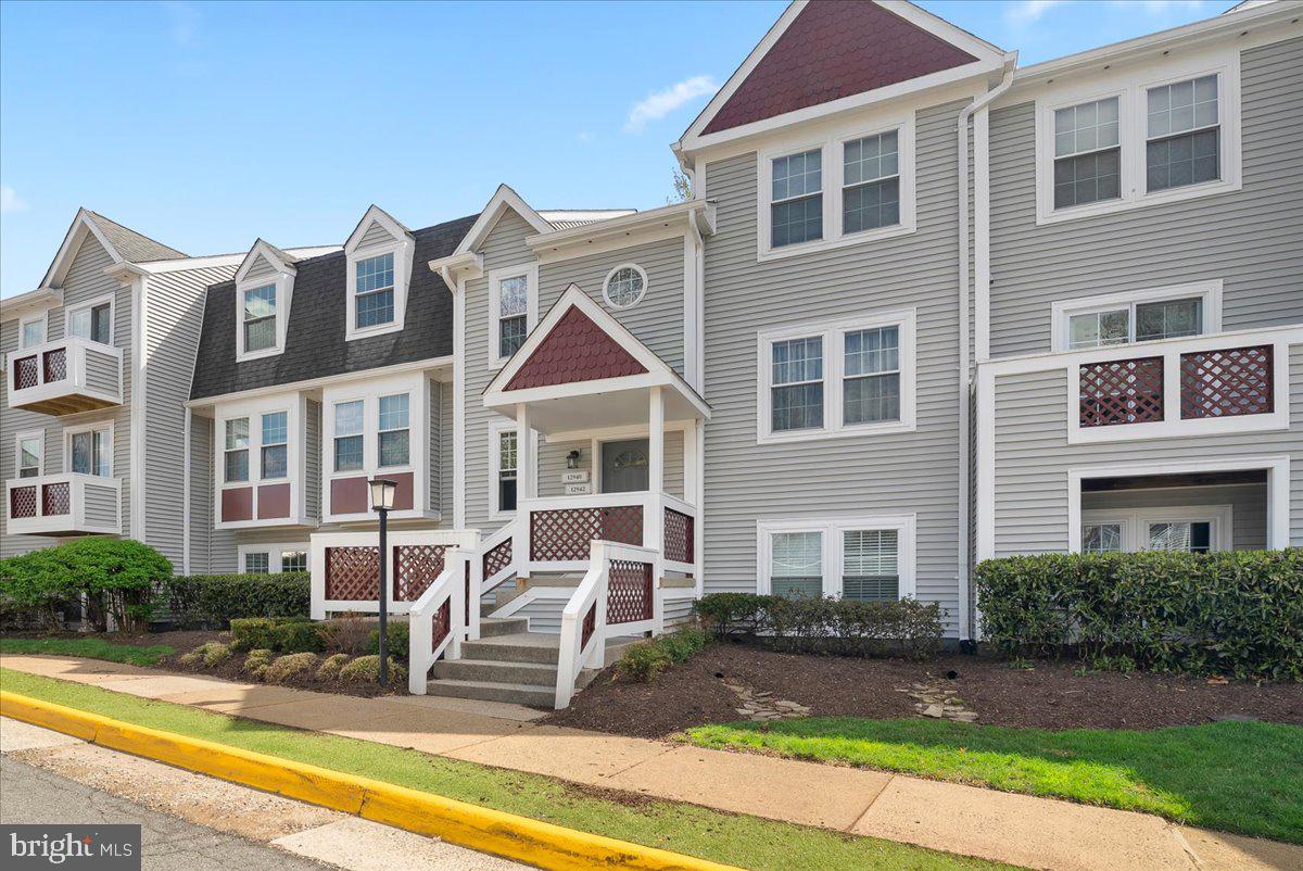 12942 A Grays Pointe Road, Unit 12942A Fairfax, VA 22033 - Photo 3 of 22 a front view of a residential apartment building with a yard and potted plants