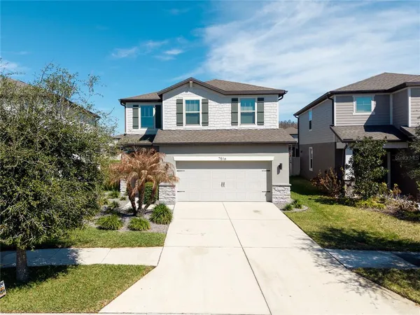 a front view of a house with a yard and garage