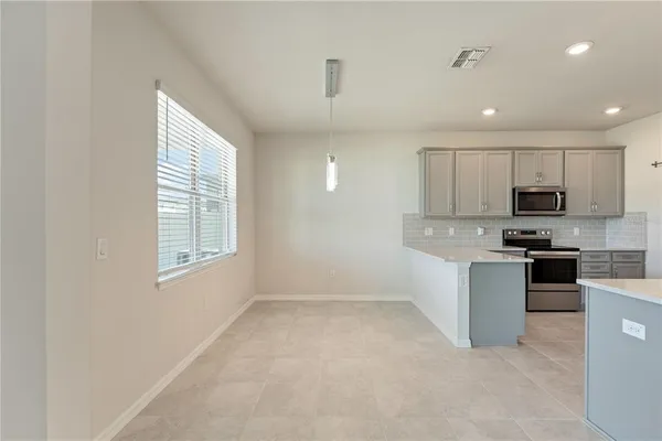 a kitchen with stainless steel appliances granite countertop a refrigerator sink and white cabinets