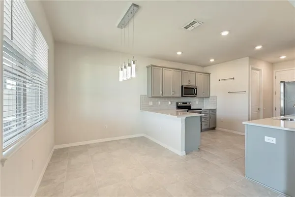 a large kitchen with kitchen island a sink stainless steel appliances and cabinets