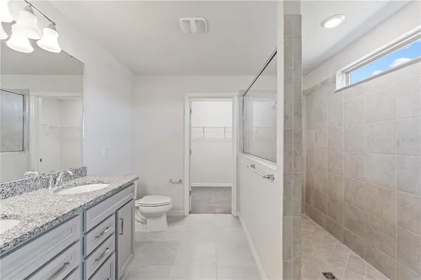 a bathroom with a granite countertop sink a large mirror and a shower