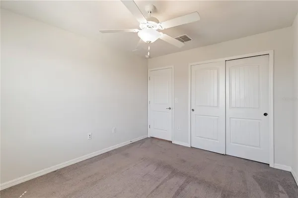 an empty room with a window and a fan