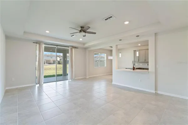 an empty room with a ceiling fan and carpet