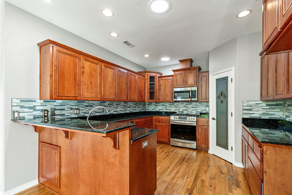 1034 Buck Point Street Central Point, OR 97502 - Photo 21 of 43 a kitchen with stainless steel appliances granite countertop a stove a sink and a refrigerator