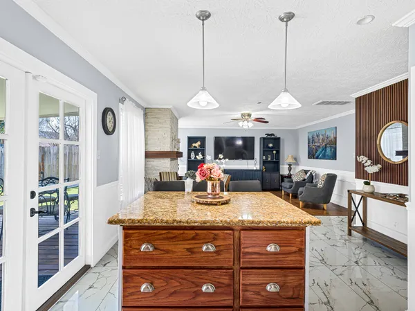 a room with kitchen island a large counter and appliances