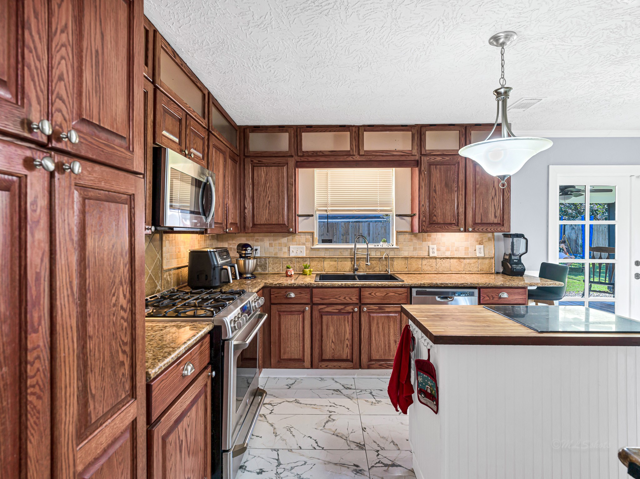 6822 Eagle Ridge Drive Katy, TX 77449 - Photo 20 of 36 a kitchen with stainless steel appliances granite countertop a sink stove a refrigerator a sink dishwasher with wooden cabinets and floor