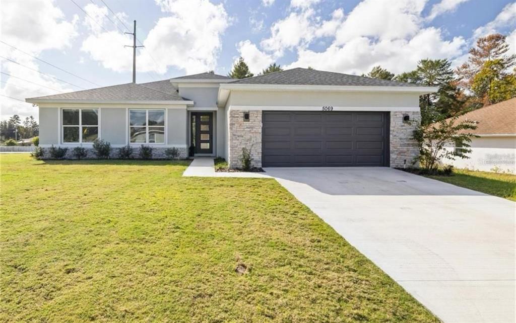 5550 Southwest 107th Street Ocala, FL 34476 - Photo 1 of 15 a front view of house with yard and swimming pool