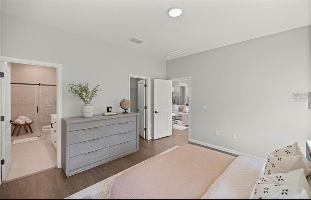 5550 Southwest 107th Street Ocala, FL 34476 - Photo 9 of 15 a spacious bedroom with a bed and a chandelier
