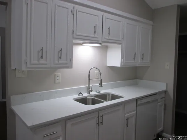 a kitchen with stainless steel appliances granite countertop a sink a stove and cabinets