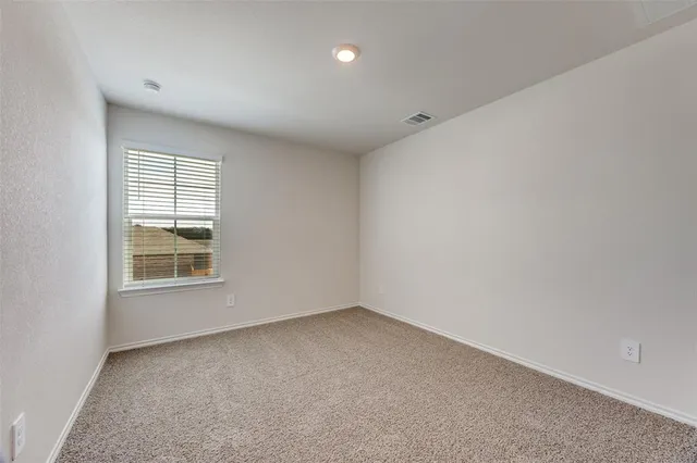 an empty room with a cabinet and mirrors
