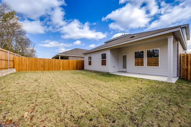 a view of backyard with wooden fence