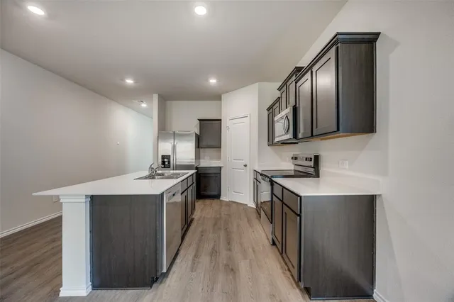 a large kitchen with stainless steel appliances lots of counter space and windows