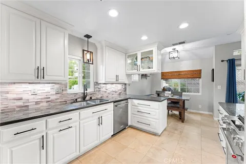 a kitchen with stainless steel appliances a sink stove and cabinets