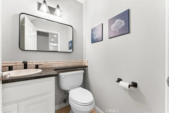 a bathroom with a toilet sink vanity and mirror