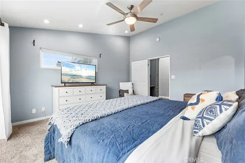 a bedroom with a bed and dresser with mirror