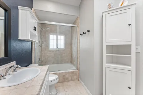 a bathroom with a granite countertop sink a toilet and shower
