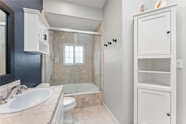 a bathroom with a granite countertop sink a toilet and shower