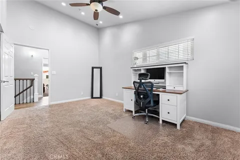 a view of a workspace with furniture and a window