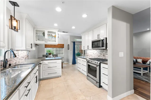 a kitchen with stainless steel appliances granite countertop a sink stove oven and refrigerator