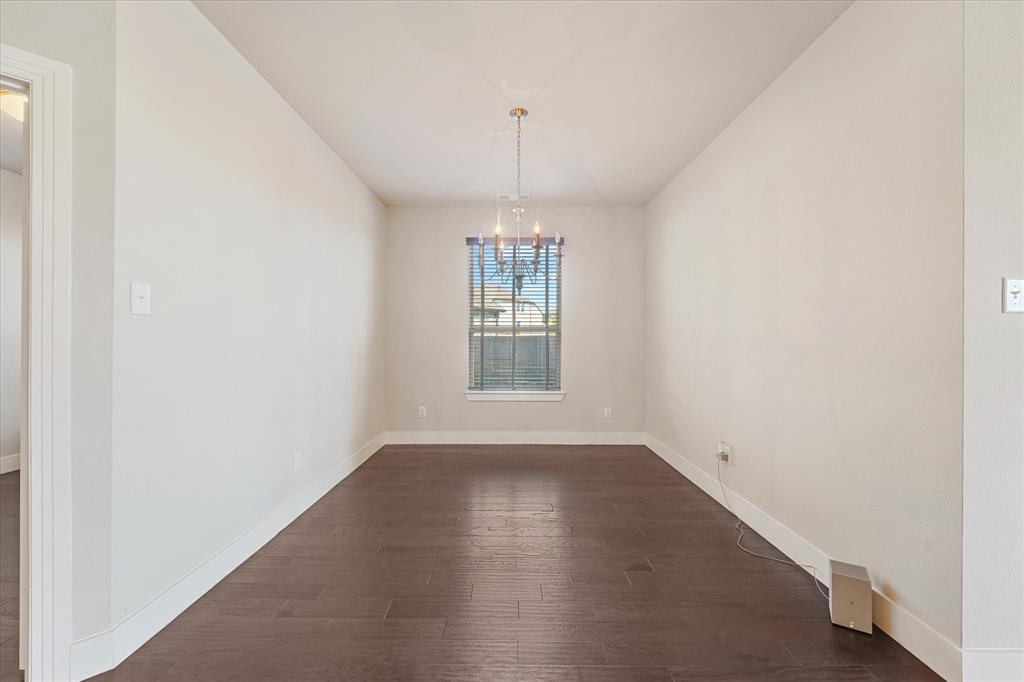 Wood-finish flooring, neutral wall tones, and a chandelier lighting fixture