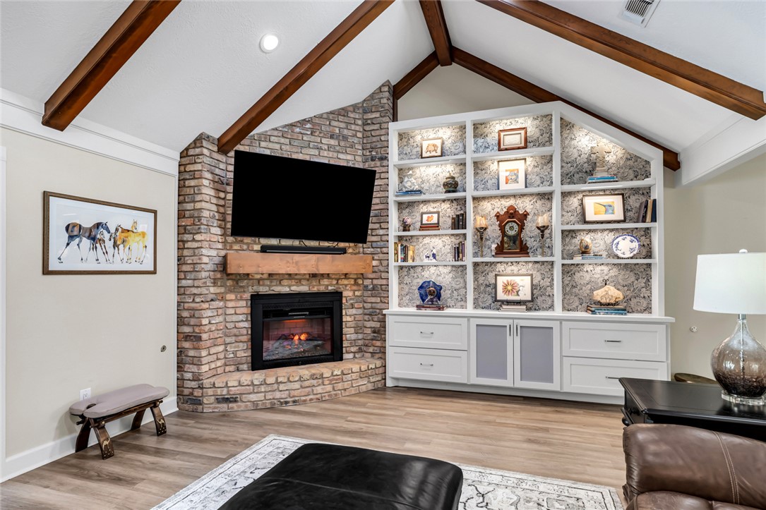 a living room with furniture a flat screen tv and a fireplace
