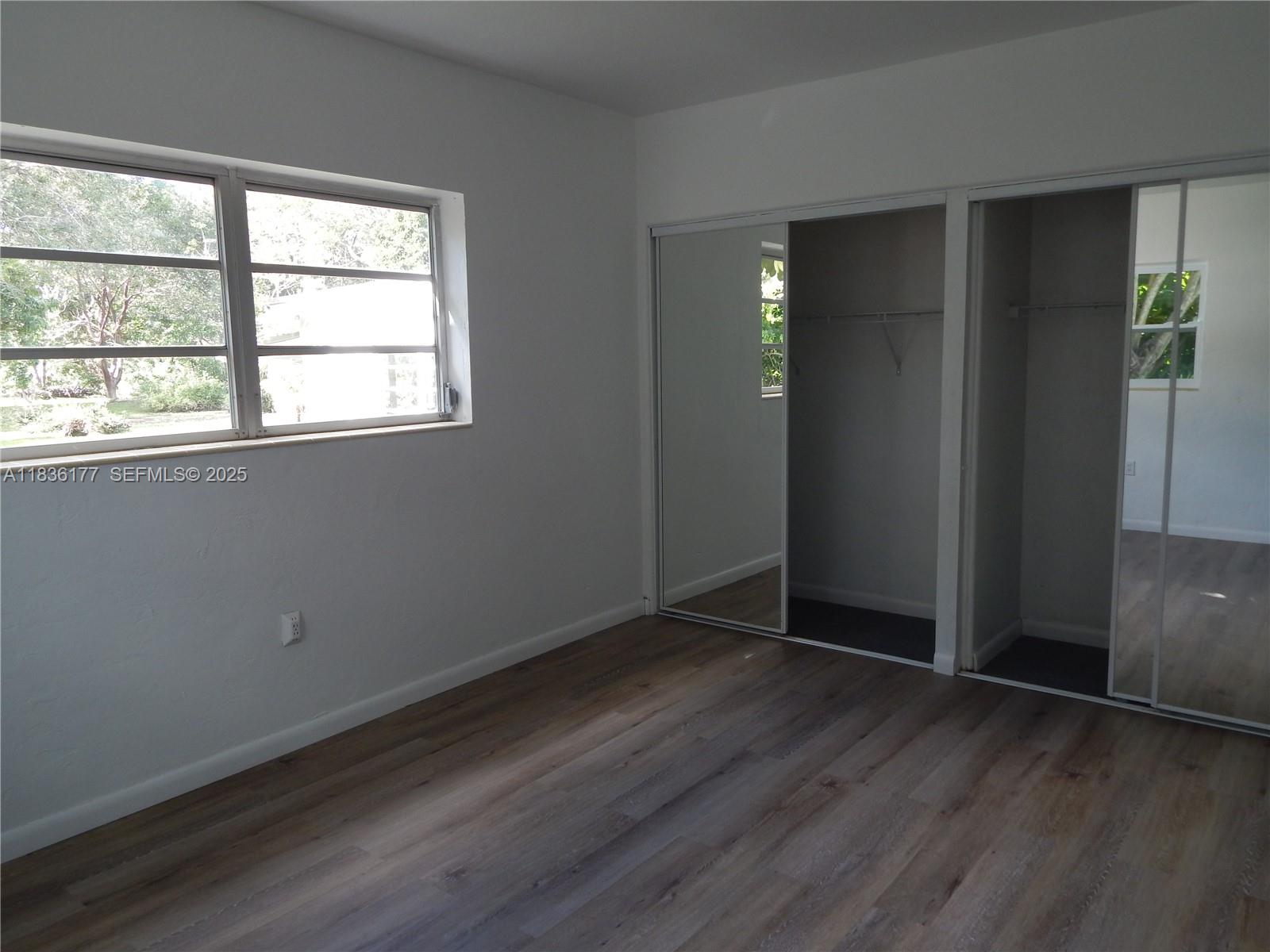 7800 Southwest 69th Avenue Miami, FL 33143 - Photo 14 of 24 an empty room with wooden floor and windows