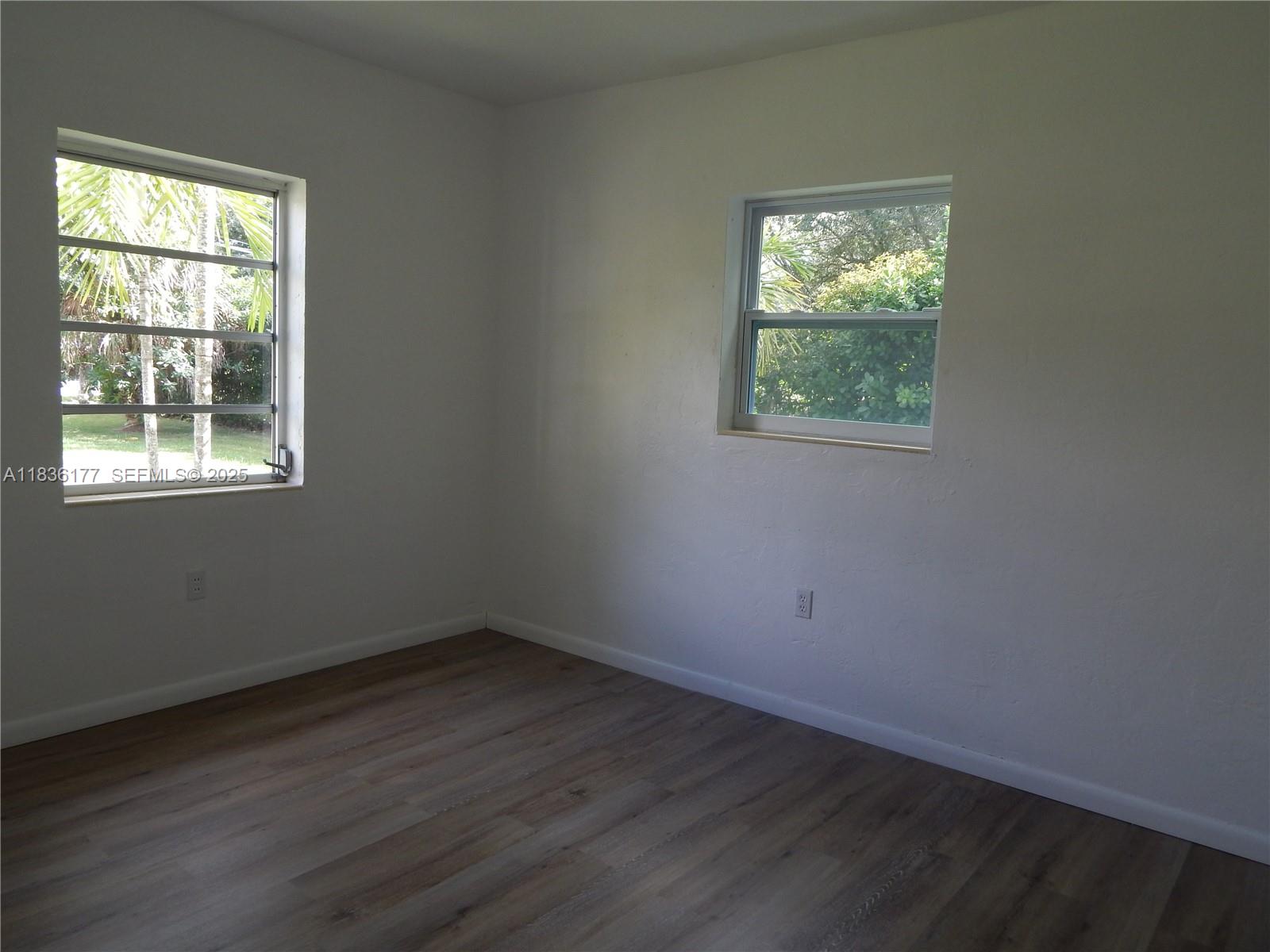 7800 Southwest 69th Avenue Miami, FL 33143 - Photo 15 of 24 an empty room with wooden floor and windows