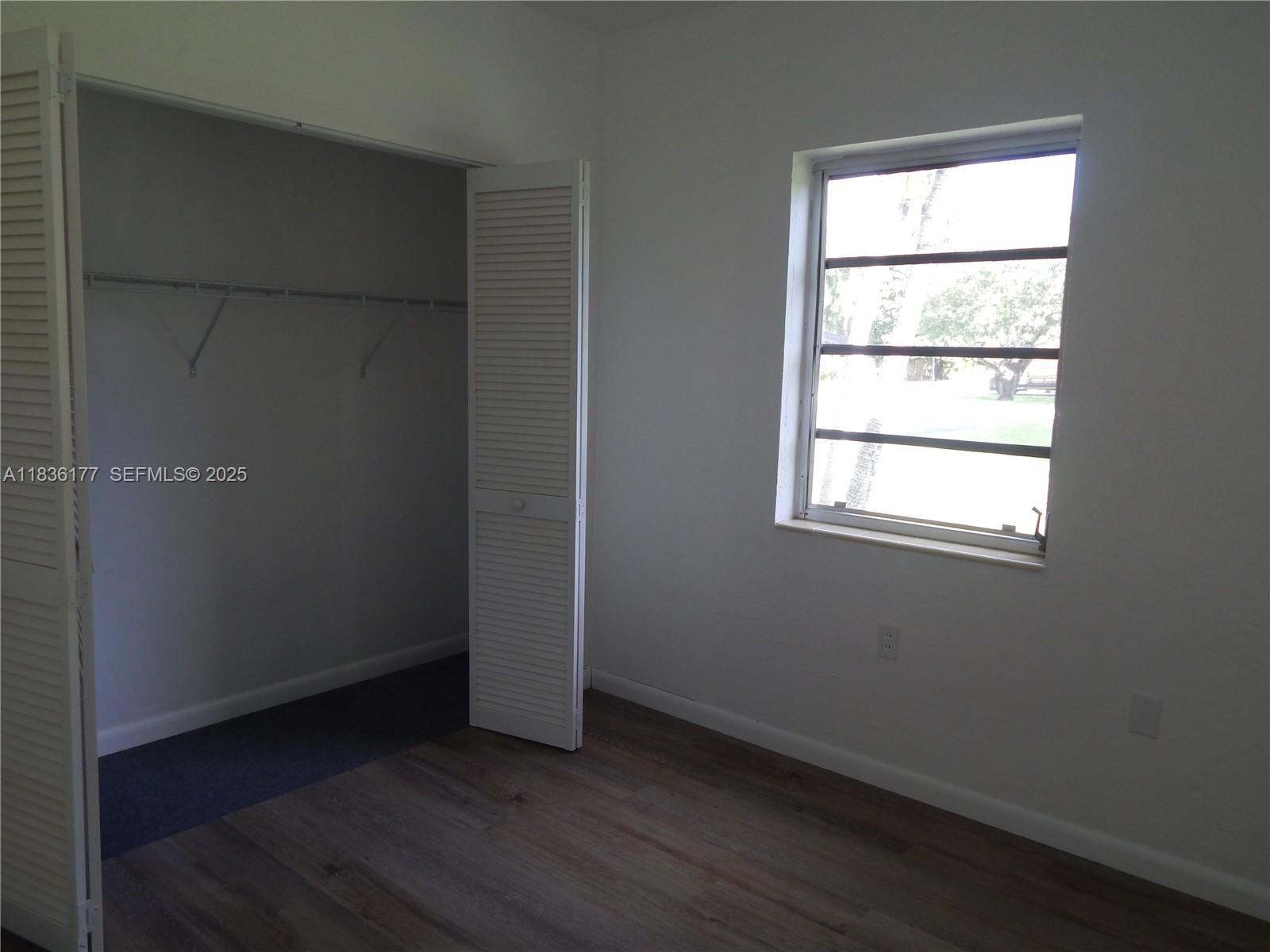 7800 Southwest 69th Avenue Miami, FL 33143 - Photo 16 of 24 an empty room with wooden floor and windows