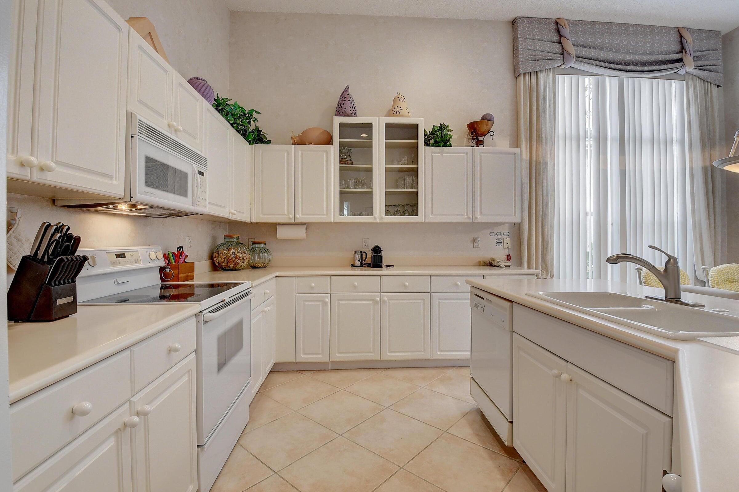 7725 Rockford Road Boynton Beach, FL 33472 - Photo 11 of 47 a kitchen with granite countertop a sink stainless steel appliances and cabinets