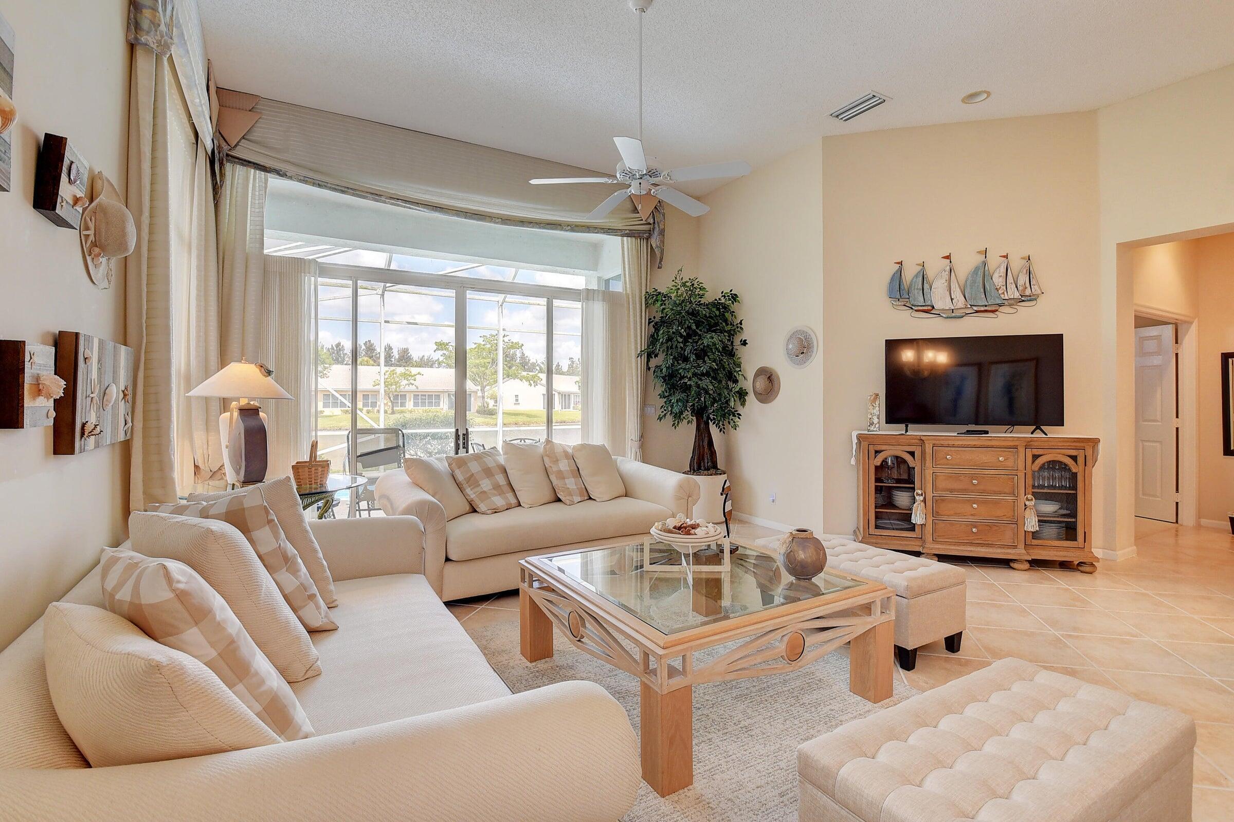7725 Rockford Road Boynton Beach, FL 33472 - Photo 8 of 47 a living room with furniture a flat screen tv and a large window