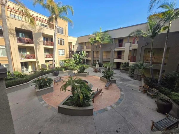 a view of a building with backyard garden and patio