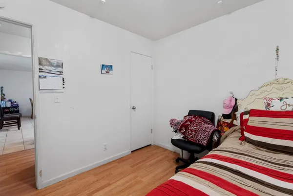a bedroom with two beds and wooden floor