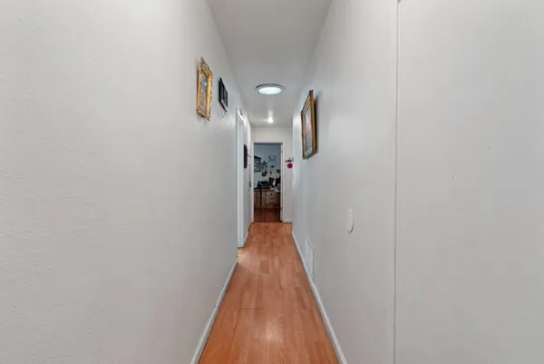 a view of a hallway with wooden floor and staircase
