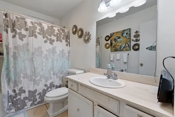 a bathroom with a granite countertop sink mirror vanity and toilet