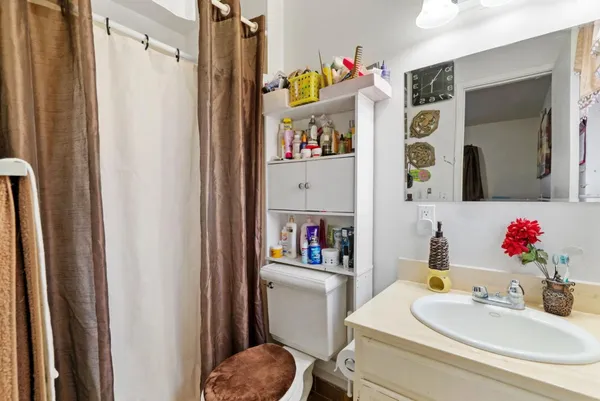 a bathroom with a sink vanity mirror and toilet