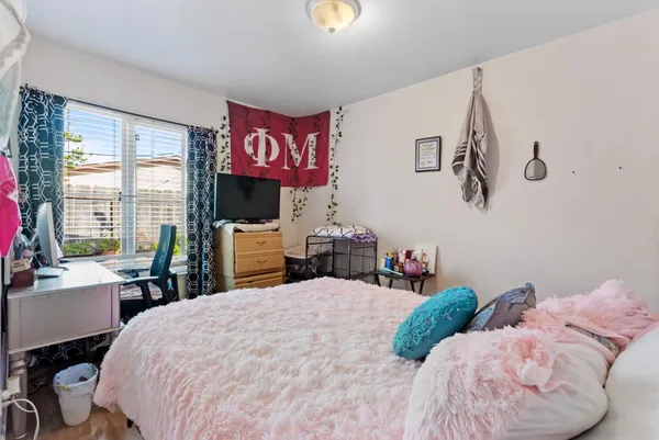 a bedroom with a bed and dresser with mirror