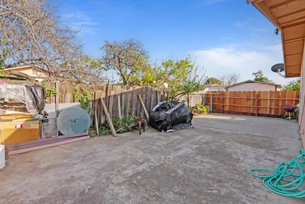 a backyard of a house with table and chairs and potted plants