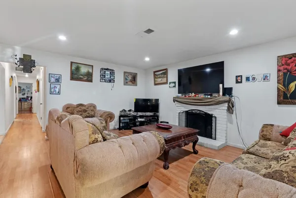 a living room with furniture a flat screen tv and a fireplace