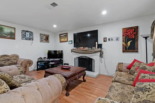 a living room with furniture a flat screen tv and a fireplace