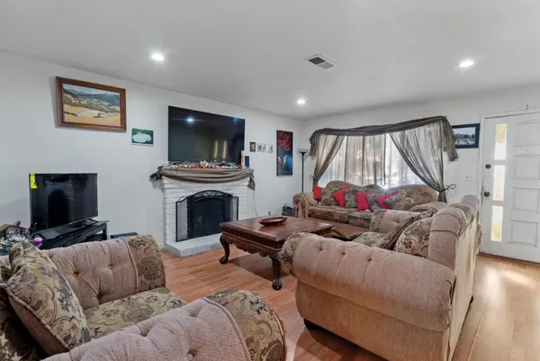 a living room with furniture a flat screen tv and a fireplace