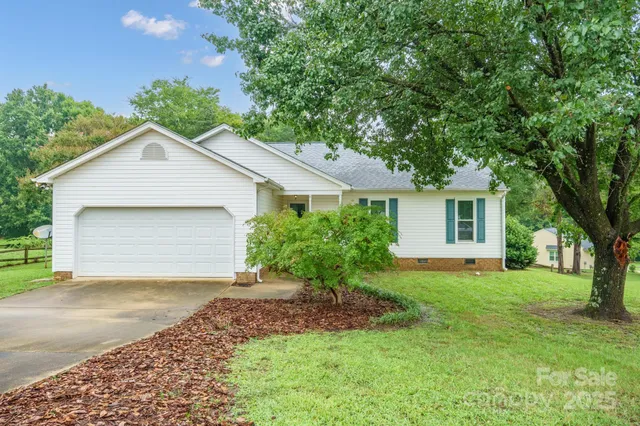 a front view of a house with a garden and trees