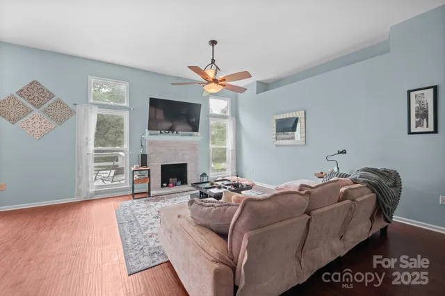 a living room with furniture a flat screen tv and a fireplace