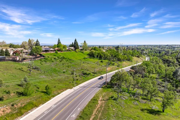 an aerial view of residential houses with outdoor space and trees