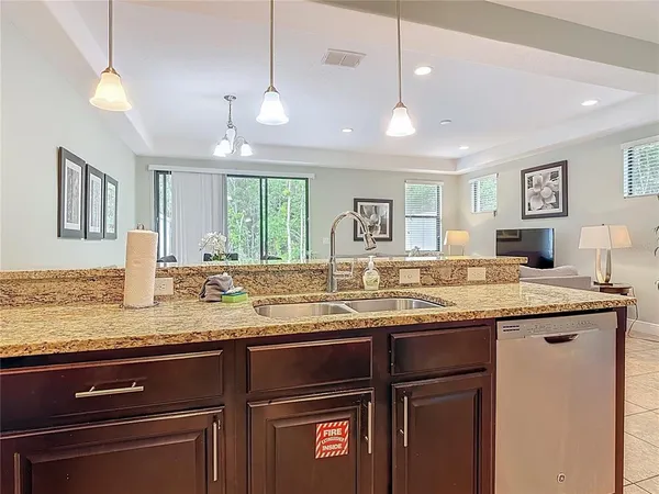 a kitchen with stainless steel appliances granite countertop a stove refrigerator sink and cabinets